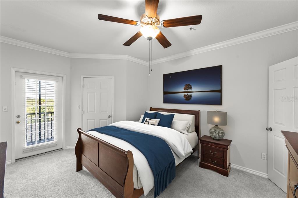 A bedroom features a wooden bed, a ceiling fan, a nightstand, and a glass door — 4305 BAYSIDE VILLAGE DRIVE UNIT 202, TAMPA, FL
