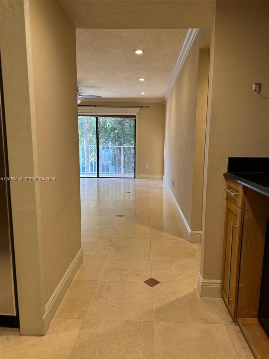 A tiled hallway leads to a living area with a sliding glass door to a balcony — 9301 SW 92nd Ave # 212B, Miami FL 33176, MIAMI, FL