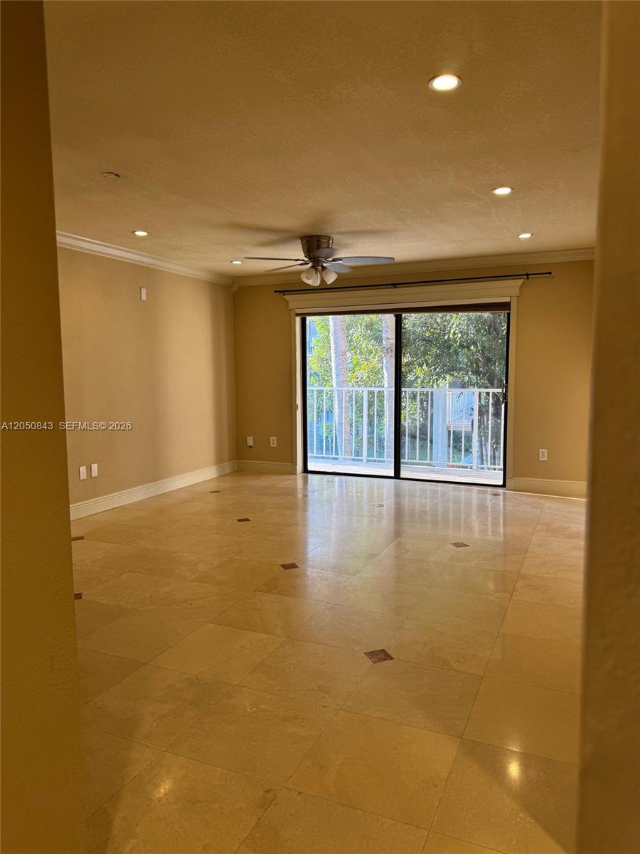 An empty living room features beige tile flooring, a ceiling fan, and sliding glass doors — 9301 SW 92nd Ave # 212B, Miami FL 33176, MIAMI, FL
