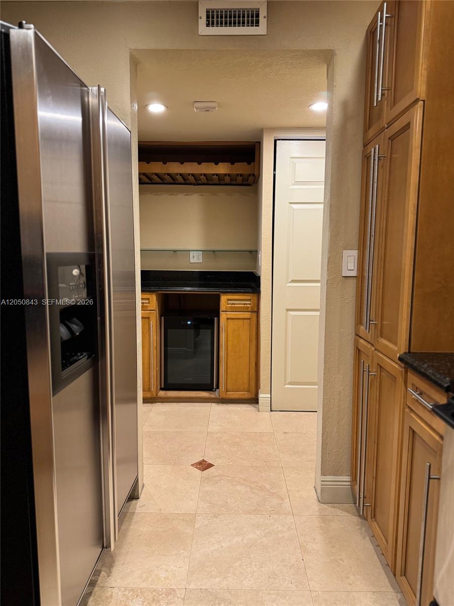 A kitchen features stainless steel appliances, wood cabinetry, and a small built-in wine cooler — 9301 SW 92nd Ave # 212B, Miami FL 33176, MIAMI, FL