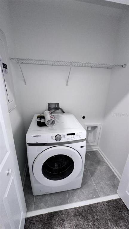 A laundry closet contains a white Samsung front-load washing machine and a wire storage shelf — 334 BOGEY DRIVE, DAVENPORT, FL
