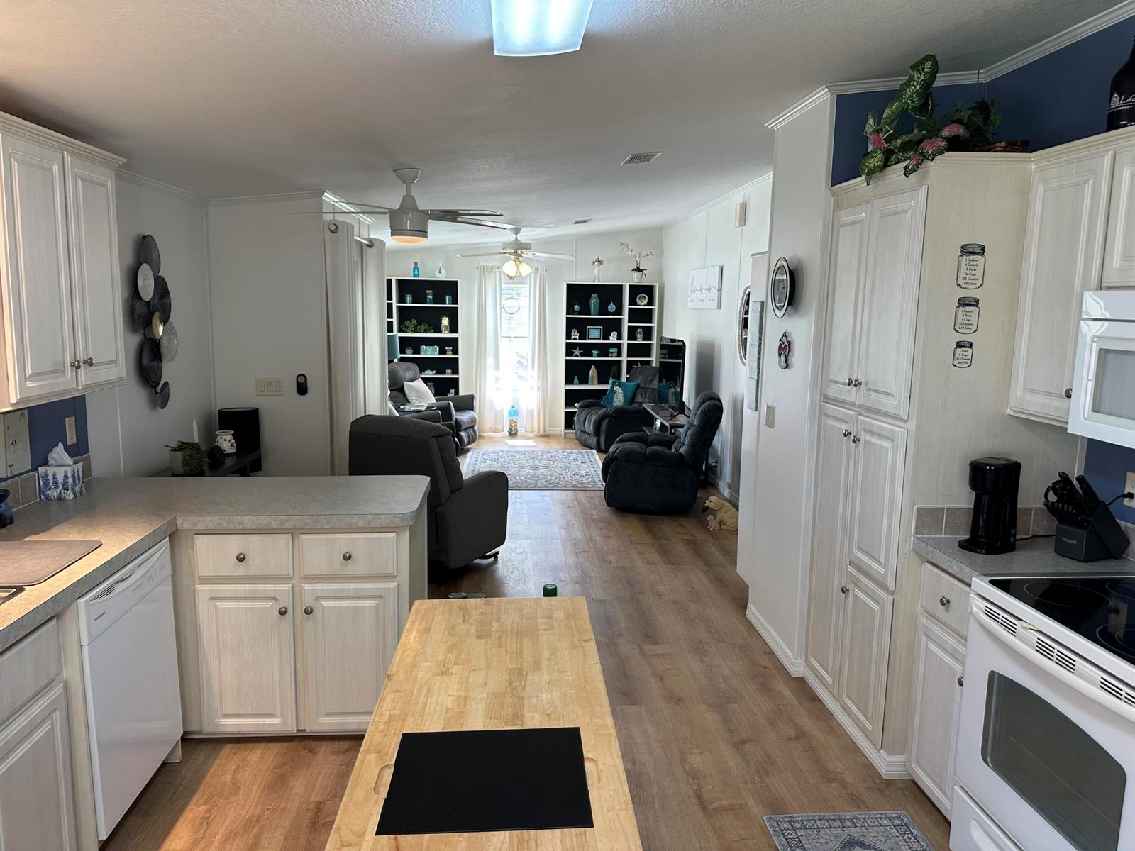 A kitchen with white cabinets and a wooden island opens into a living room area — 500 Thames Bluff Ridge # 24, Fort Pierce FL 34982, FORT PIERCE, FL