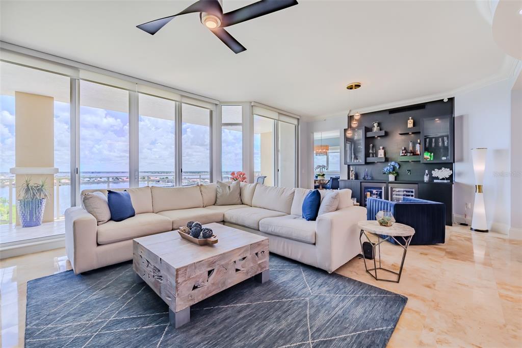 A living room features a large sectional sofa, a wooden coffee table, and a wet bar — 130 RIVIERA DUNES WAY UNIT 802, PALMETTO, FL