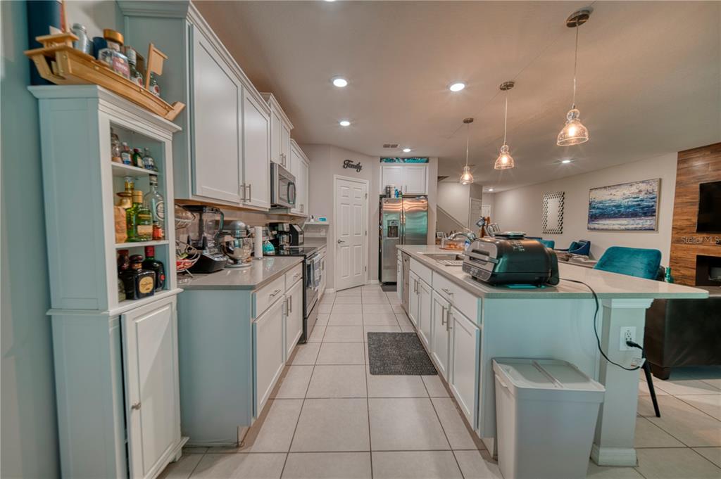 A kitchen with white cabinets, gray countertops, a center island, and tile flooring — 3390 BELLEZZA COURT, KISSIMMEE, FL