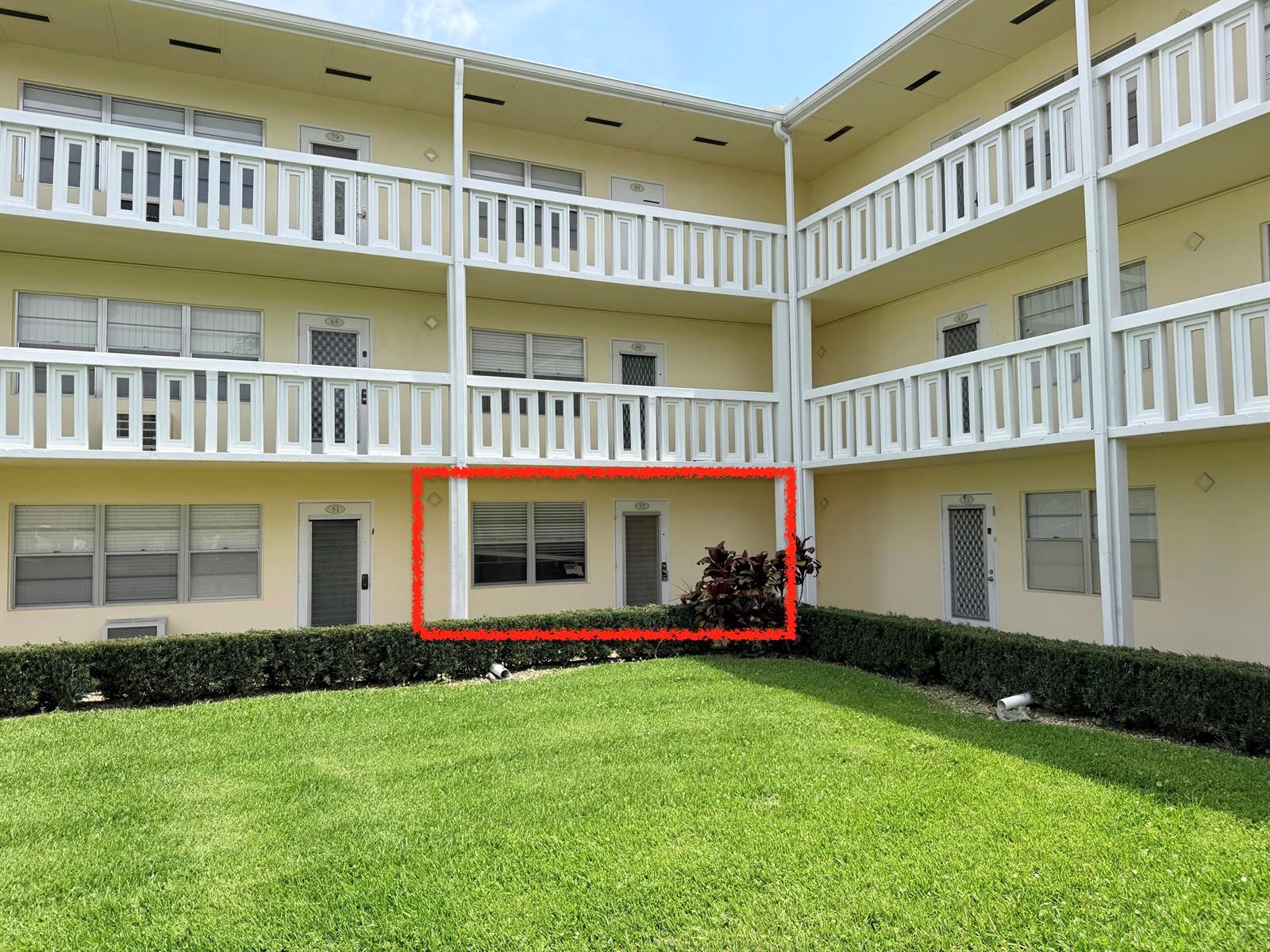 A ground-floor apartment unit with a window and door facing a grassy courtyard — 52 Dorset Drive # B, Boca Raton FL 33434, BOCA RATON, FL