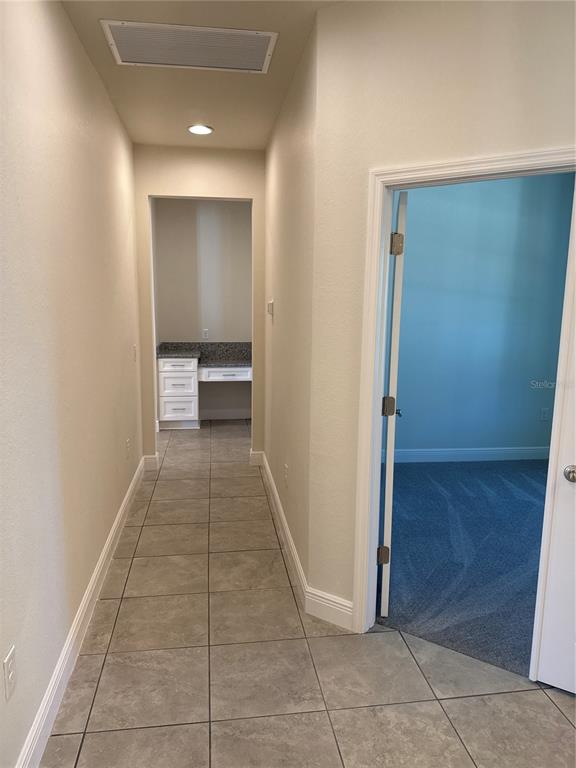 A hallway with tile flooring leads to a small built-in desk area — 5372 JODY AVENUE, NORTH PORT, FL