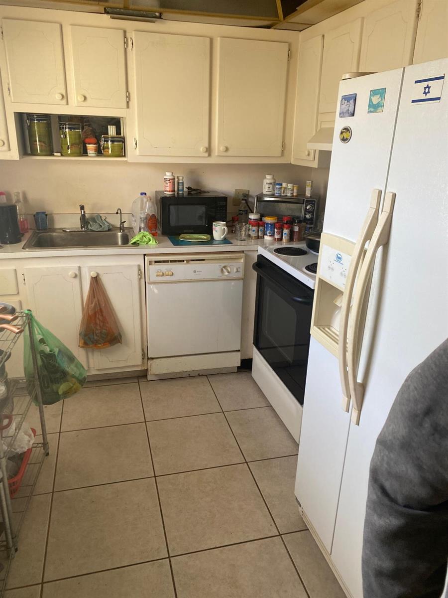 A kitchen features white cabinets, a dishwasher, a stove, and a white refrigerator — 668 Monaco N # 668, Delray Beach FL 33446, DELRAY BEACH, FL