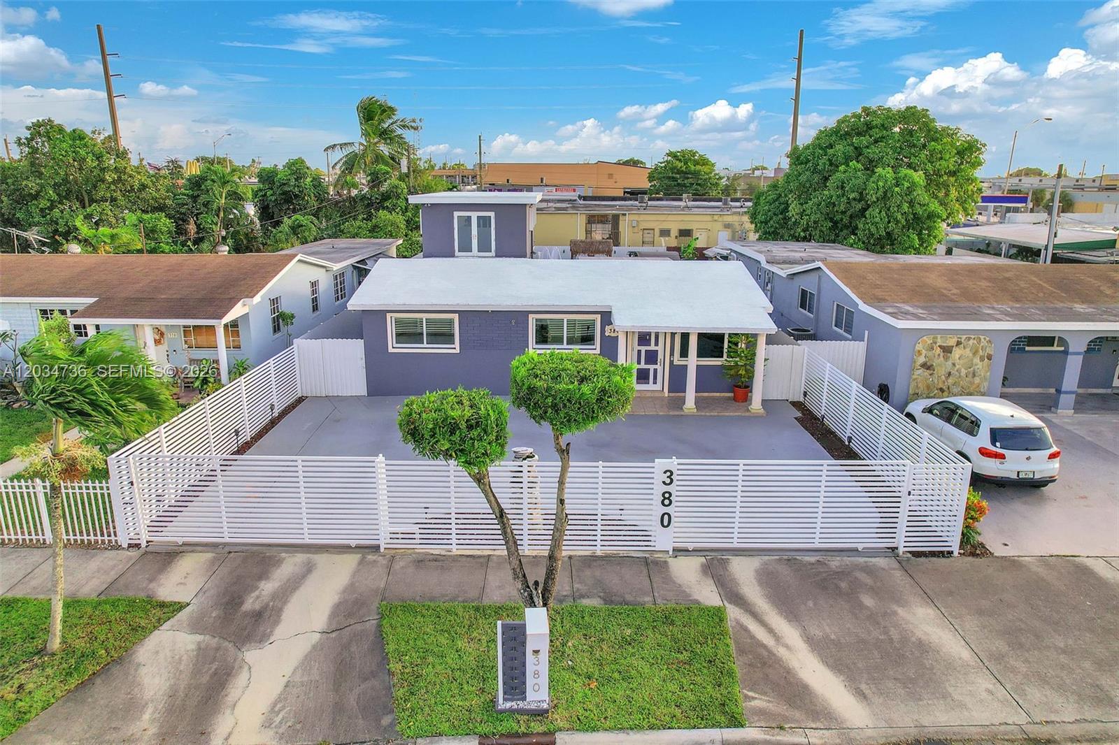 An aerial view of a single-story house with a white fence and a paved driveway — 380 W 30th St, Hialeah FL 33012, HIALEAH, FL