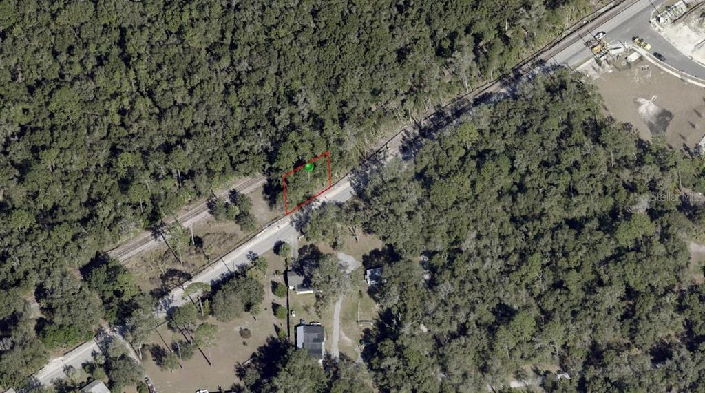 An aerial view shows a rectangular plot of land outlined in red near a road — OLD NEW YORK AVENUE, DELAND, FL