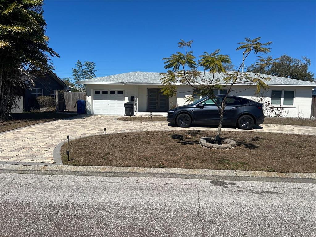 A single-story house with a paved driveway, a dark car, and a small tree in front — 4127 28TH AVENUE N, ST PETERSBURG, FL