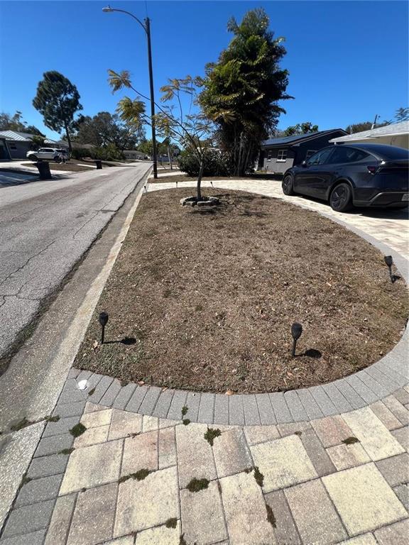 A paved driveway leads to a small, circular lawn area with a young tree — 4127 28TH AVENUE N, ST PETERSBURG, FL