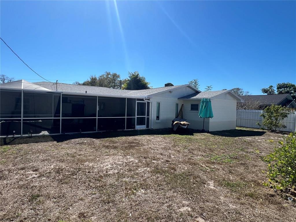 The backyard features a screened-in patio, a light-colored house, and a white vinyl fence — 4127 28TH AVENUE N, ST PETERSBURG, FL