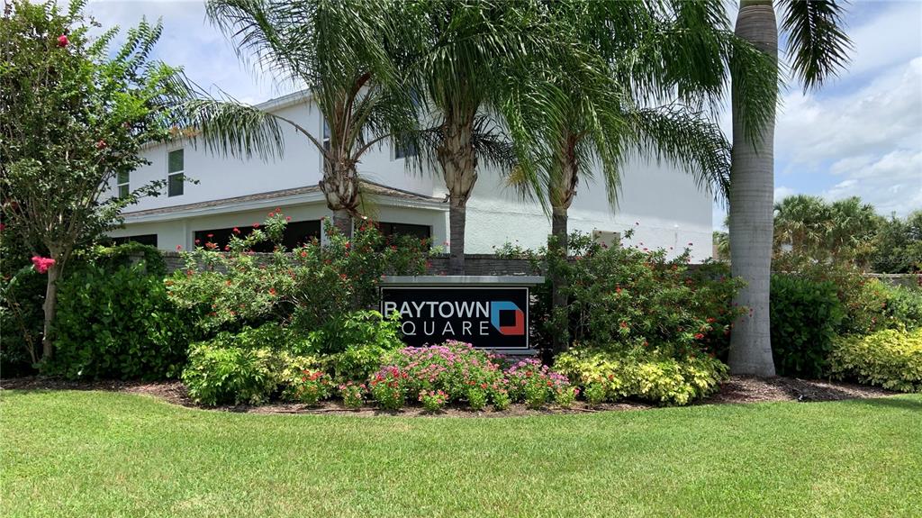 A sign for Baytown Square stands in front of a multi-story building and palm trees — 6461 BAYTOWN DRIVE, SARASOTA, FL