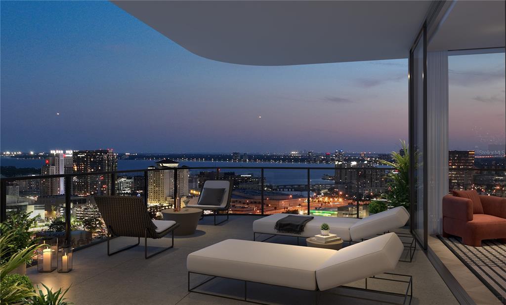 This rendering shows a modern balcony at dusk with lounge chairs overlooking a city skyline — 1101 E JACKSON STREET, TAMPA, FL