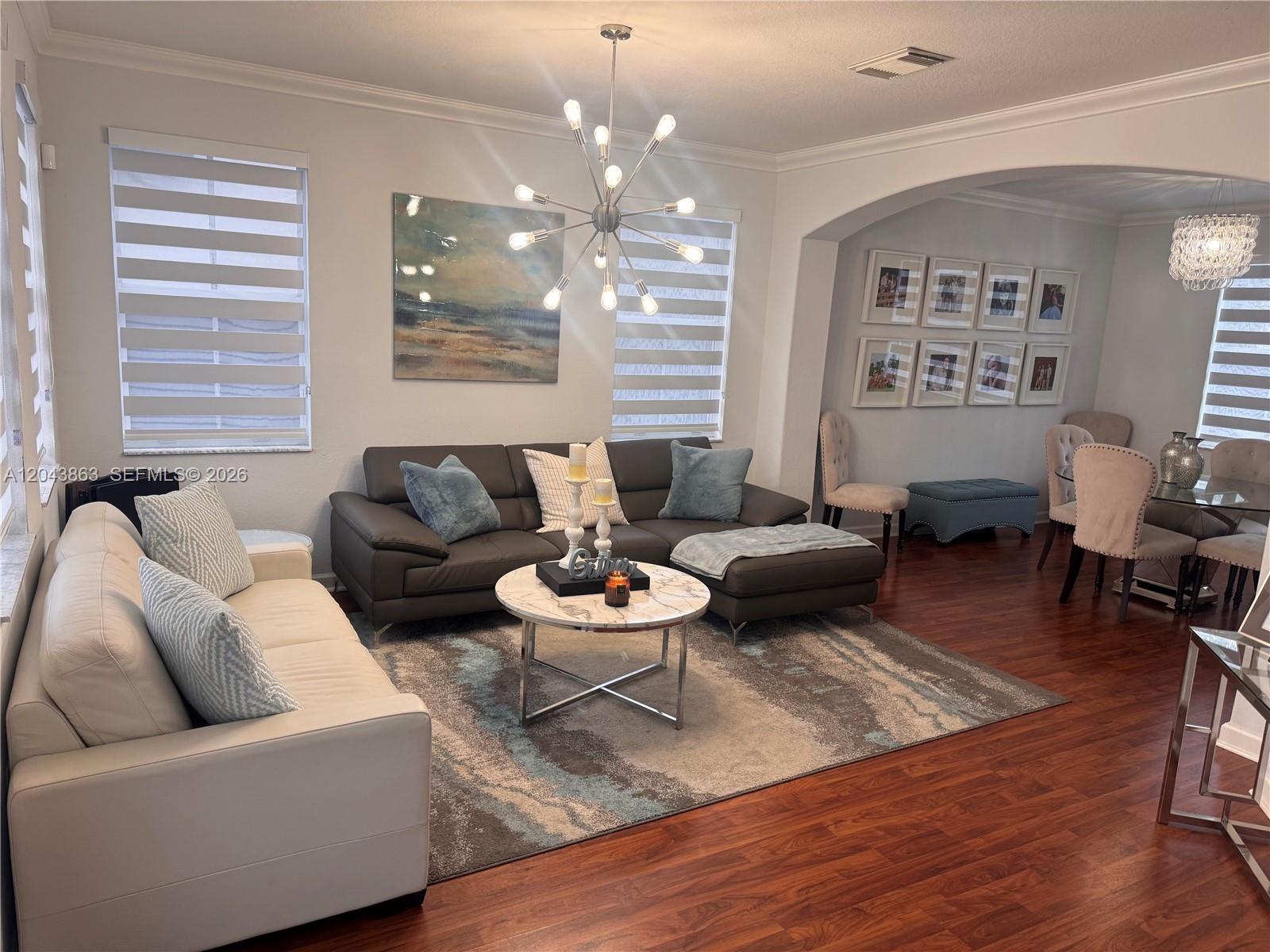 A living room features a dark sectional, a white sofa, and a modern chandelier — 15376 SW 13th Ter, Miami FL 33194, MIAMI, FL