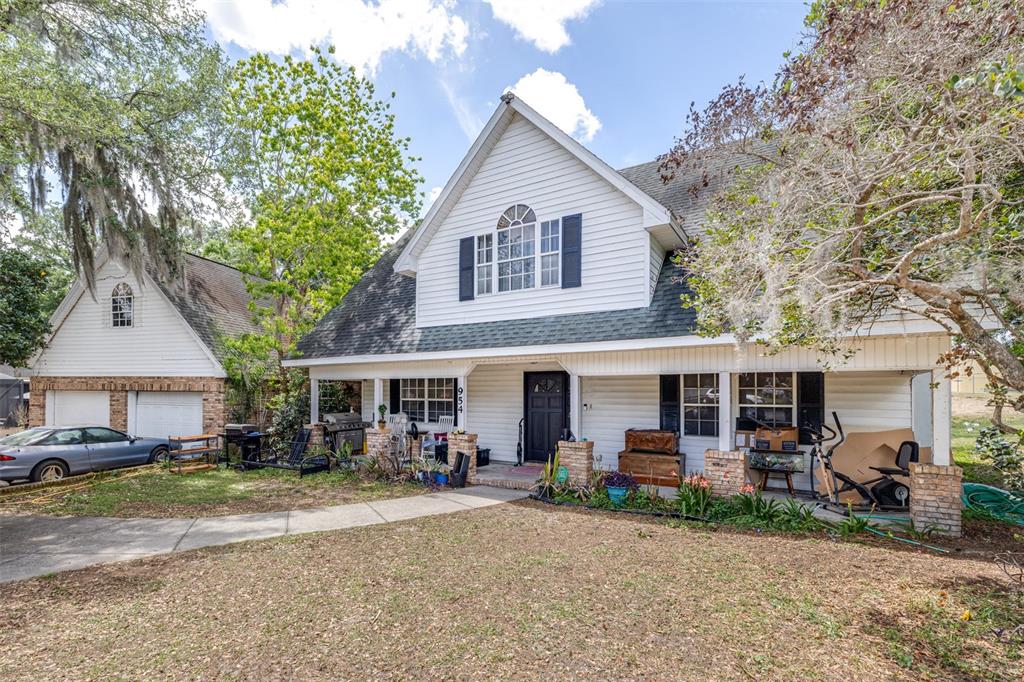 A two-story house with white siding, a front porch, and an attached garage — 954 ODONIEL DRIVE, LAKELAND, FL
