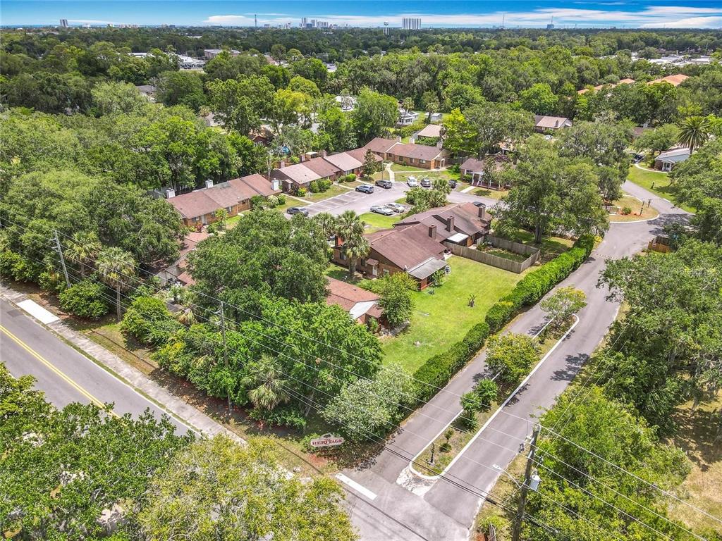 An aerial view shows a residential complex with brown-roofed buildings surrounded by trees and lawns — 1591 REVERE LANE, DAYTONA BEACH, FL