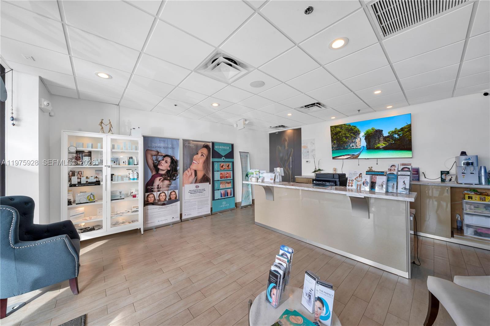 A medical spa reception area features a front desk, product displays, and promotional signage — 3749 NE 163, FL 33160, FL