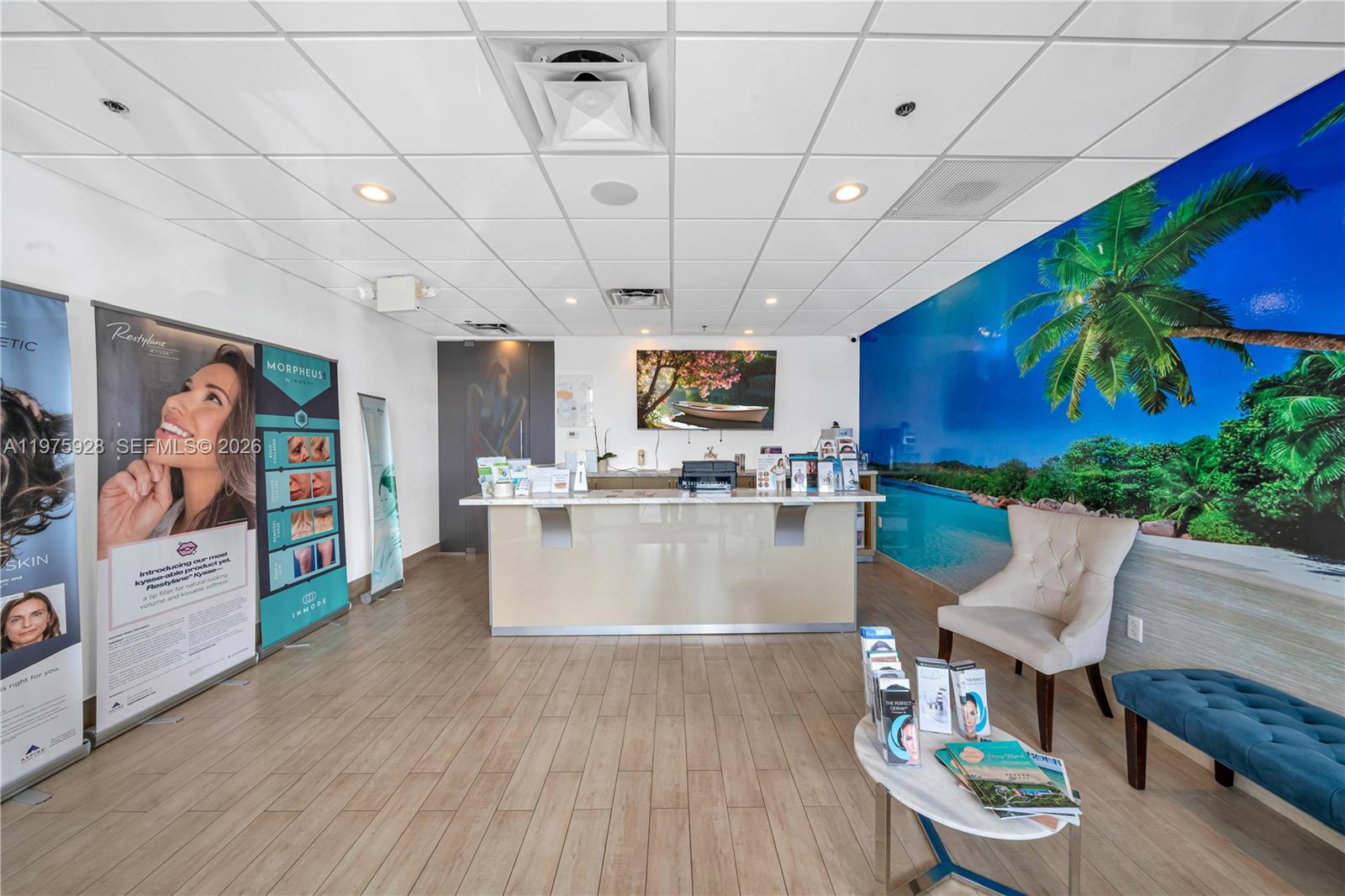 A reception area features a front desk, a large tropical wall mural, and waiting chairs — 3749 NE 163, FL 33160, FL