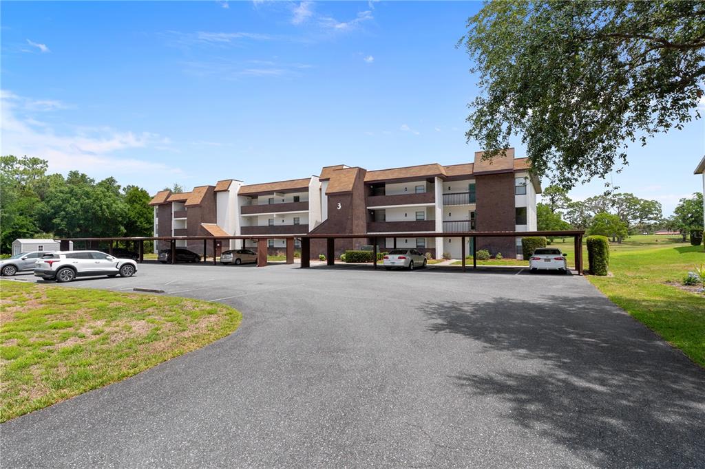 A three-story apartment building with a covered parking area in front — 3 CYPRESS RUN UNIT 31C, HOMOSASSA, FL