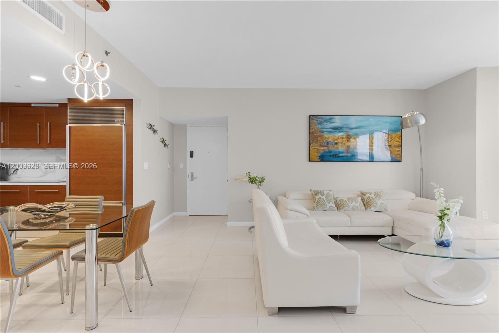 A modern living and dining area features white tile floors, white furniture, and wood cabinetry — 485 Brickell Ave # 4501, Miami FL 33131, MIAMI, FL