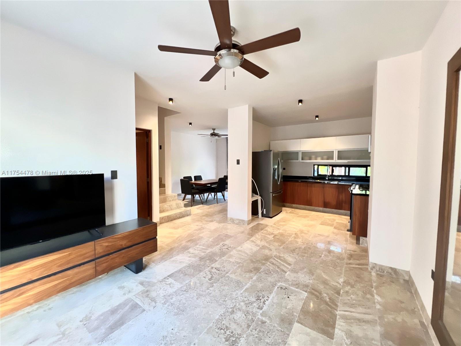 An open-concept living area features a kitchen, dining space, and stone tile flooring — Kaybe Tulum Kaybe Tulum, TX 77760, TX