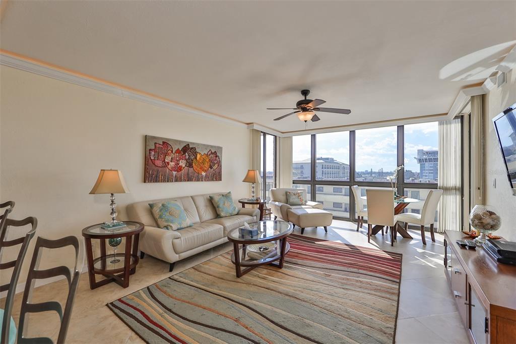 A living room features a beige sofa, a patterned area rug, and floor-to-ceiling windows — 5396 GULF BOULEVARD UNIT 701, ST PETE BEACH, FL