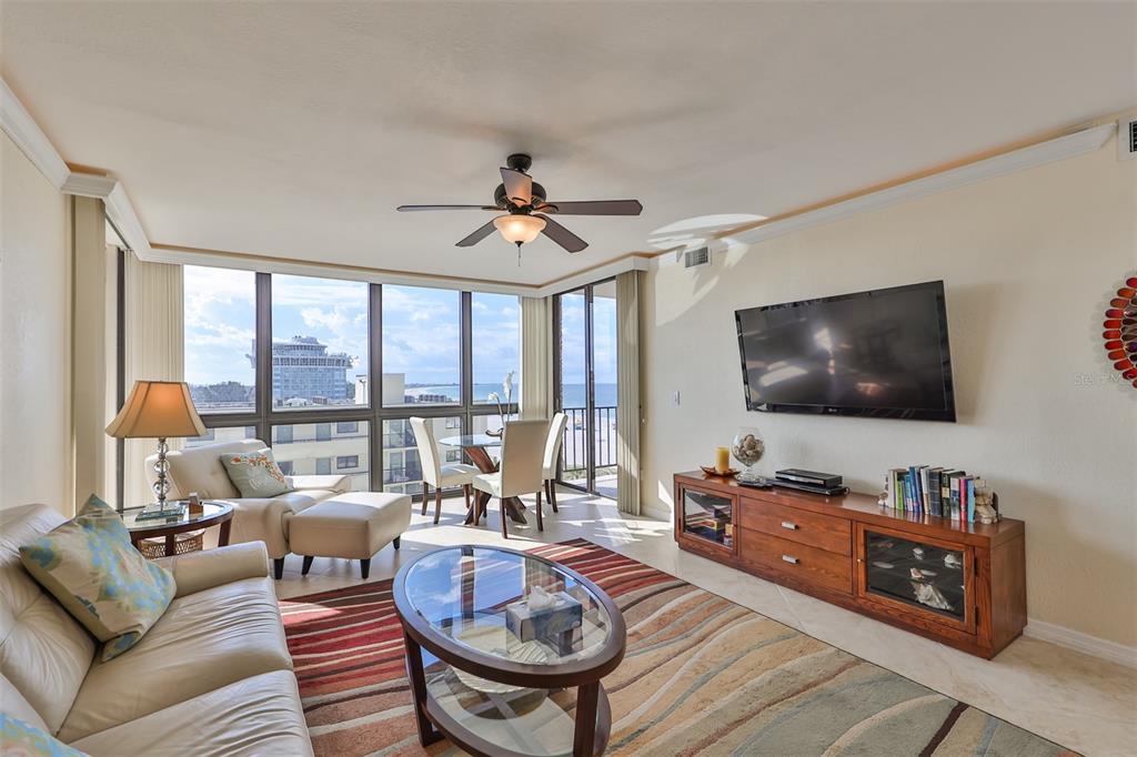A living room features a leather sofa, a glass coffee table, and floor-to-ceiling ocean views — 5396 GULF BOULEVARD UNIT 701, ST PETE BEACH, FL