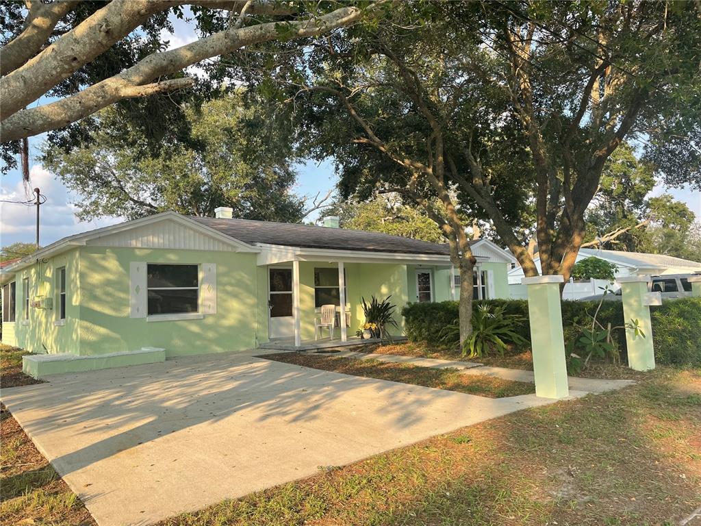 A light green single-story house with a concrete driveway and a covered front porch — 10825 NAVAJO DRIVE, ST PETERSBURG, FL