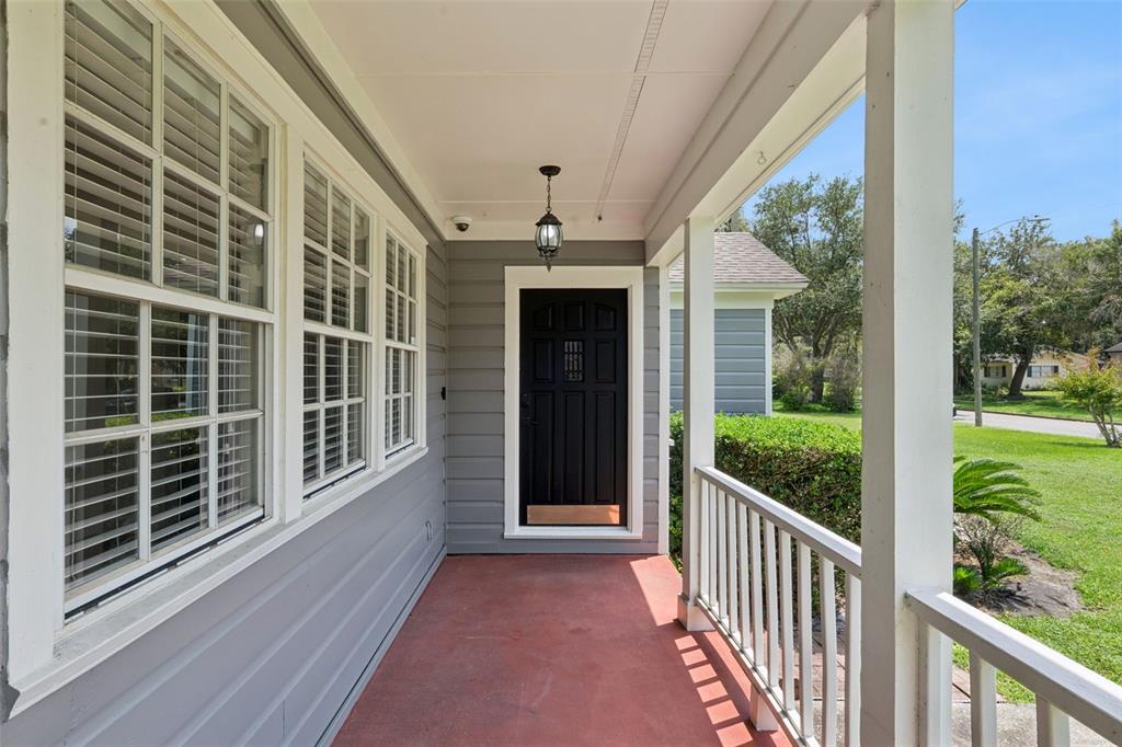 An entryway with dark hardwood floors, arched doorways, and a white built-in corner cabinet — 207 S SUMMERLIN AVENUE, SANFORD, FL