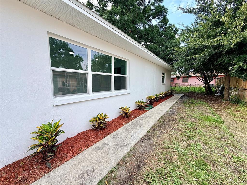 An aerial view shows residential houses, a small shed, and a stadium in the distance — 3117 W LEROY STREET, TAMPA, FL