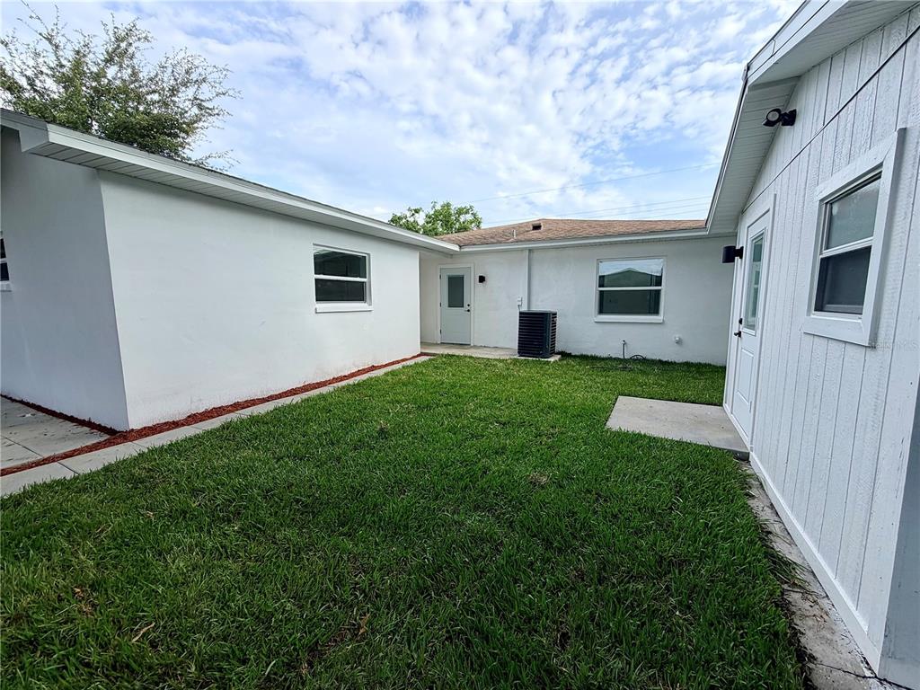 A single-story house with a red brick facade, white trim, and an attached carport — 3117 W LEROY STREET, TAMPA, FL