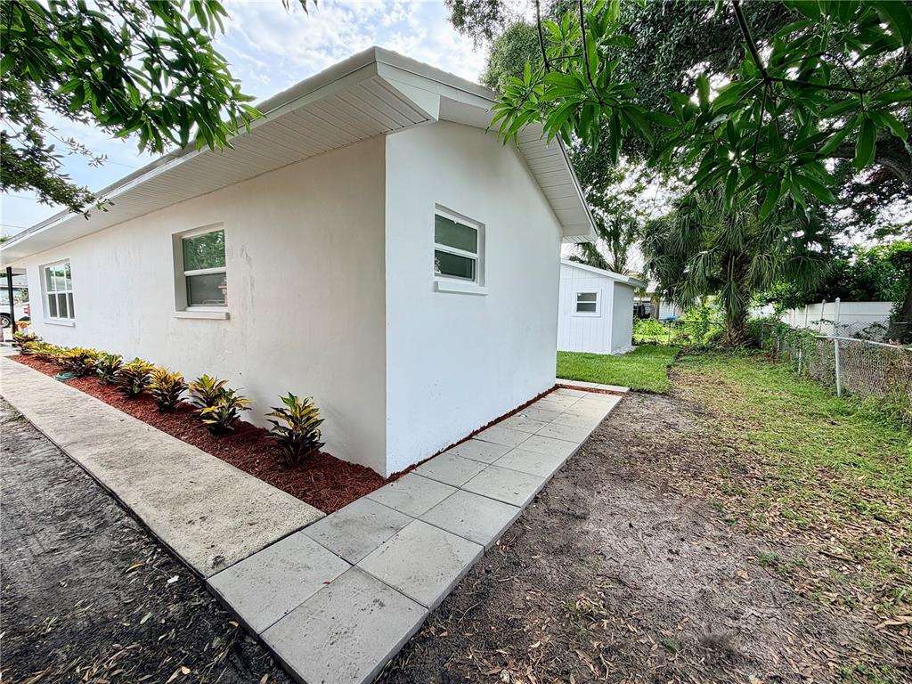 A single-story house with a white exterior, red brick accents, and a small front porch — 3117 W LEROY STREET, TAMPA, FL
