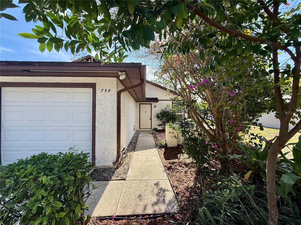 A concrete walkway leads to the front entrance of a house with a garage — 758 WARRENTON ROAD, WINTER PARK, FL