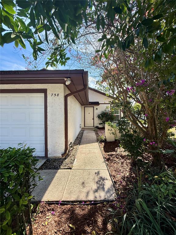 A concrete walkway leads to the front door of a house with a white garage — 758 WARRENTON ROAD, WINTER PARK, FL