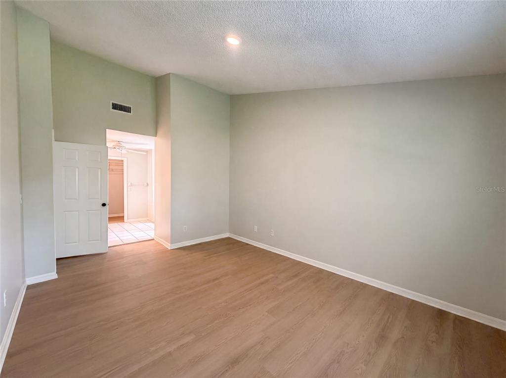 An empty room features light-colored walls, wood-look flooring, and a doorway leading to a closet — 15226 SW 39TH CIRCLE, OCALA, FL