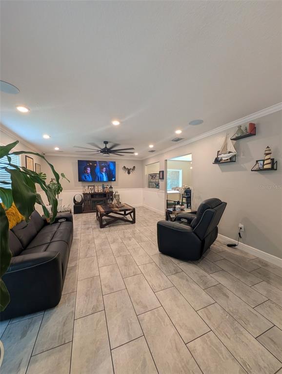 A living room features light tile flooring, a black leather sofa, and a recliner — 12076 MARVELWOOD ROAD, WEEKI WACHEE, FL