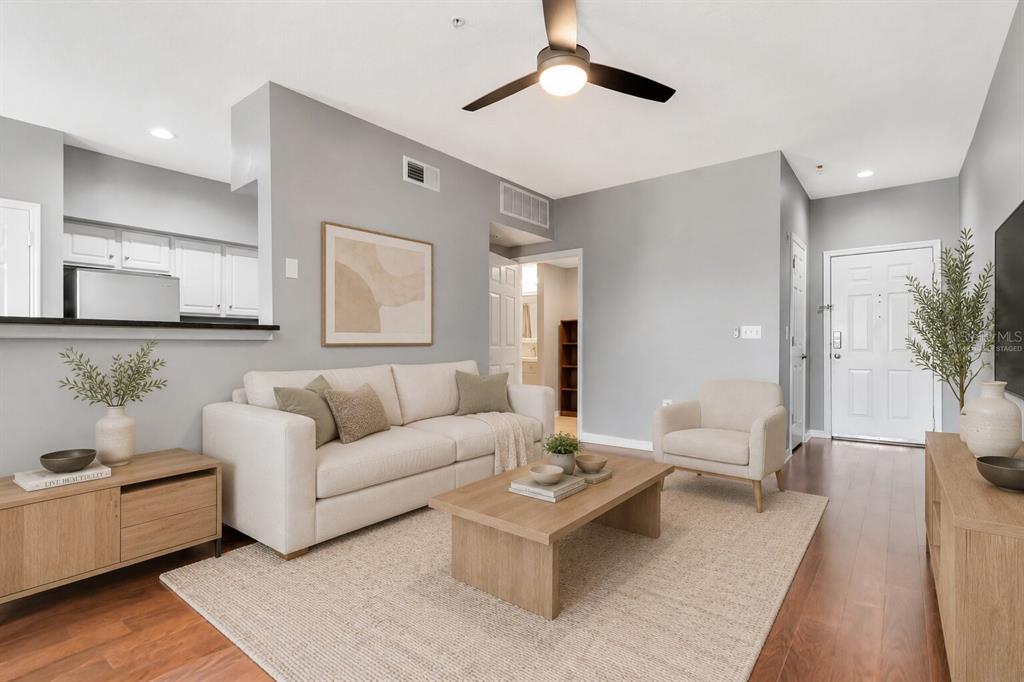 A living room features a beige sofa, a wooden coffee table, and light wood flooring — 2010 E PALM AVENUE UNIT 15310, TAMPA, FL