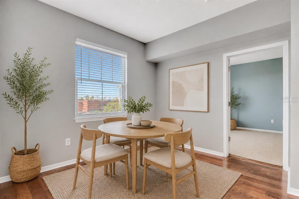 A dining area features a round wooden table, four chairs, and a window with blinds — 2010 E PALM AVENUE UNIT 15310, TAMPA, FL