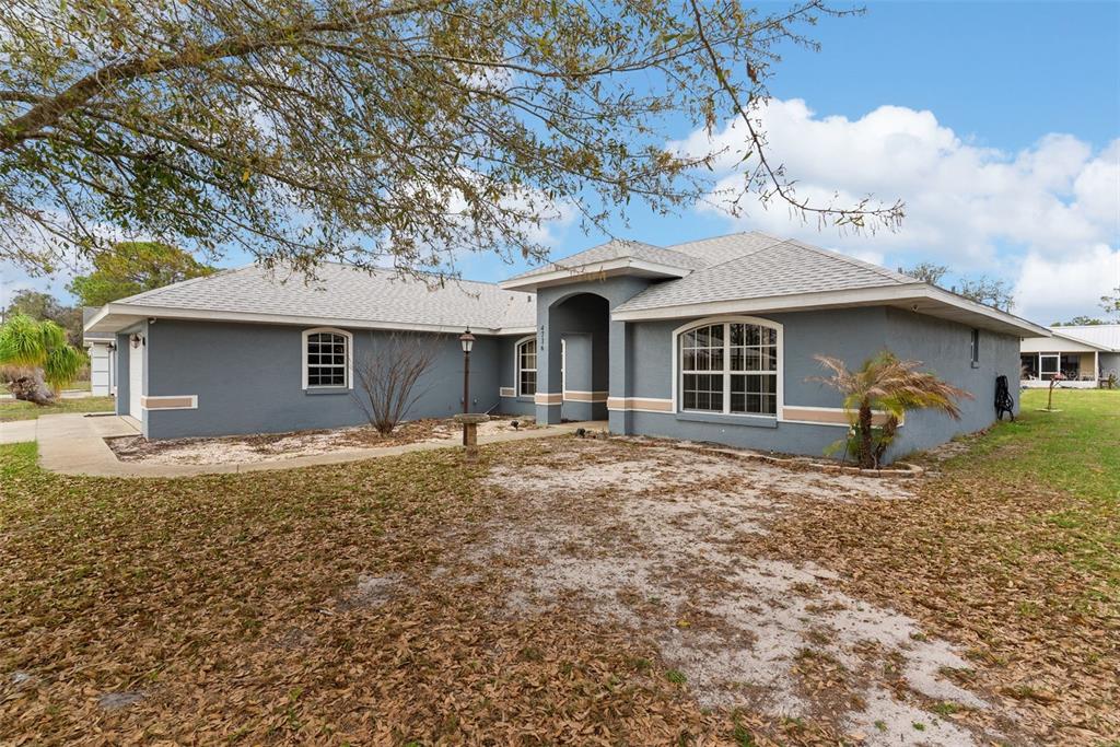 A single-story gray house with a tan trim, arched entryway, and a shingled roof — 4716 BOABADILLA AVENUE, SEBRING, FL