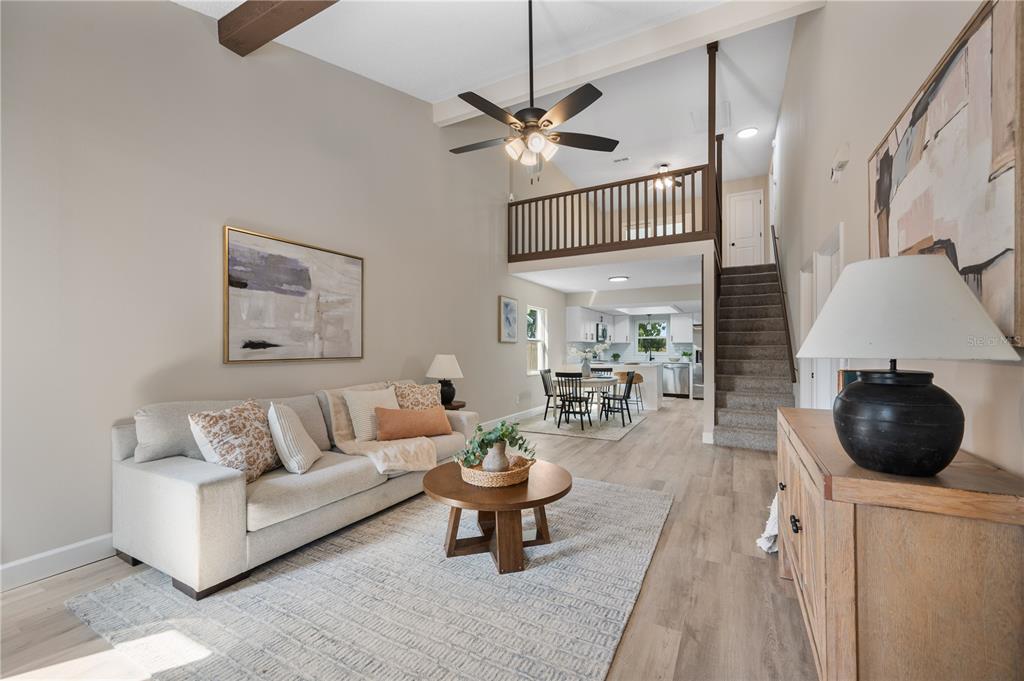 A living room with high ceilings, a loft, and an open kitchen in the background — 265 LAKE THOMAS DRIVE, WINTER HAVEN, FL