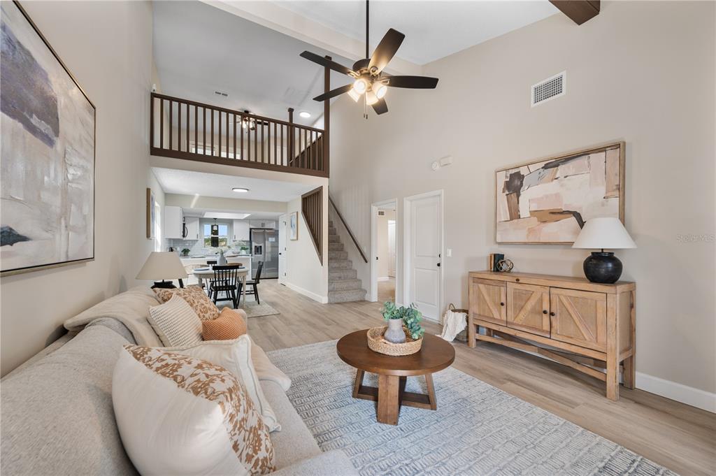 A living room with high ceilings, a loft balcony, and a wooden console table — 265 LAKE THOMAS DRIVE, WINTER HAVEN, FL