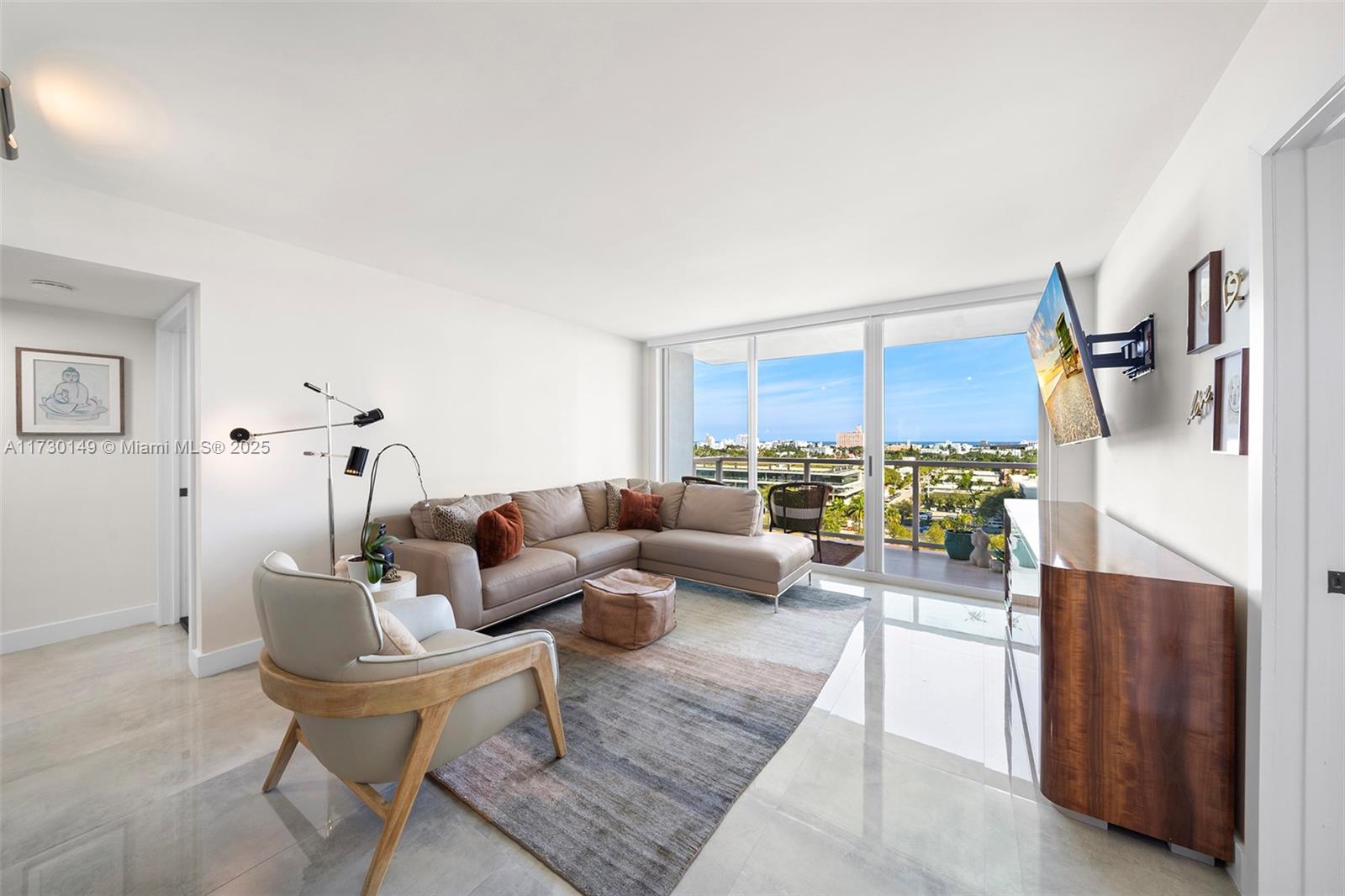 A living room features a sectional sofa, an armchair, a rug, and a balcony view — 650 West Ave # 1004, Miami Beach FL 33139, MIAMI BEACH, FL