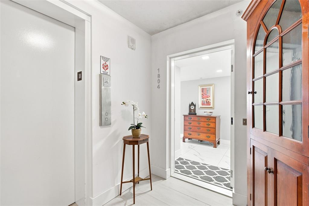 A hallway features an elevator door, a small table with a plant, and an entryway — 770 S PALM AVENUE UNIT 1804, SARASOTA, FL