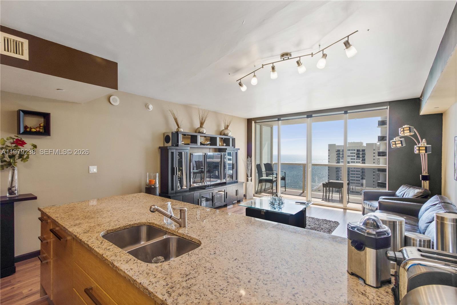A kitchen island with granite countertops overlooks a living area with ocean views — 1830 S Ocean Dr # 2105, Hallandale Beach FL 33009, HALLANDALE BEACH, FL
