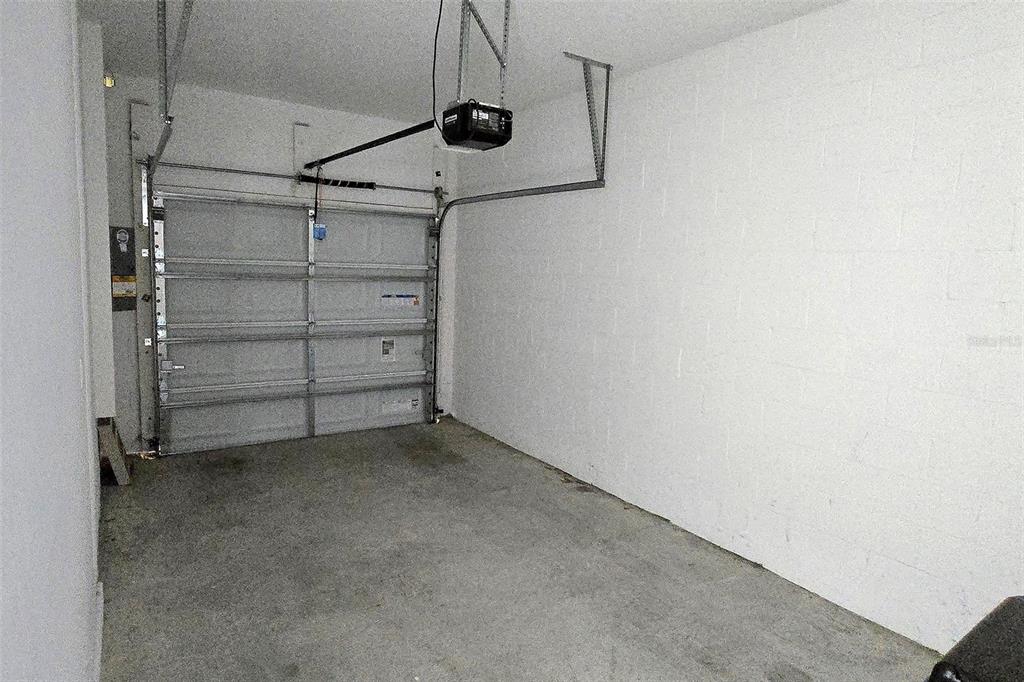 An empty garage with a concrete floor, white block walls, and a metal door — 2978 CANARY AVENUE, DAVENPORT, FL