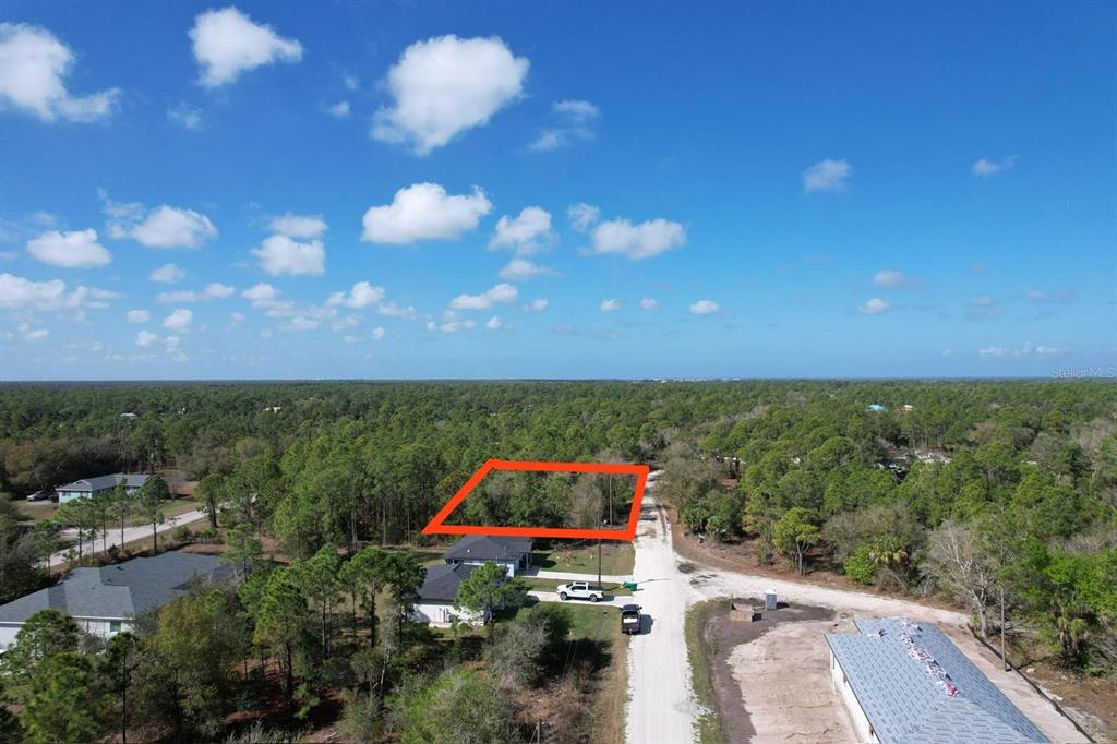 An aerial view shows a rectangular wooded lot outlined in red next to a dirt road — 28101 LAURELWOOD DRIVE, PUNTA GORDA, FL