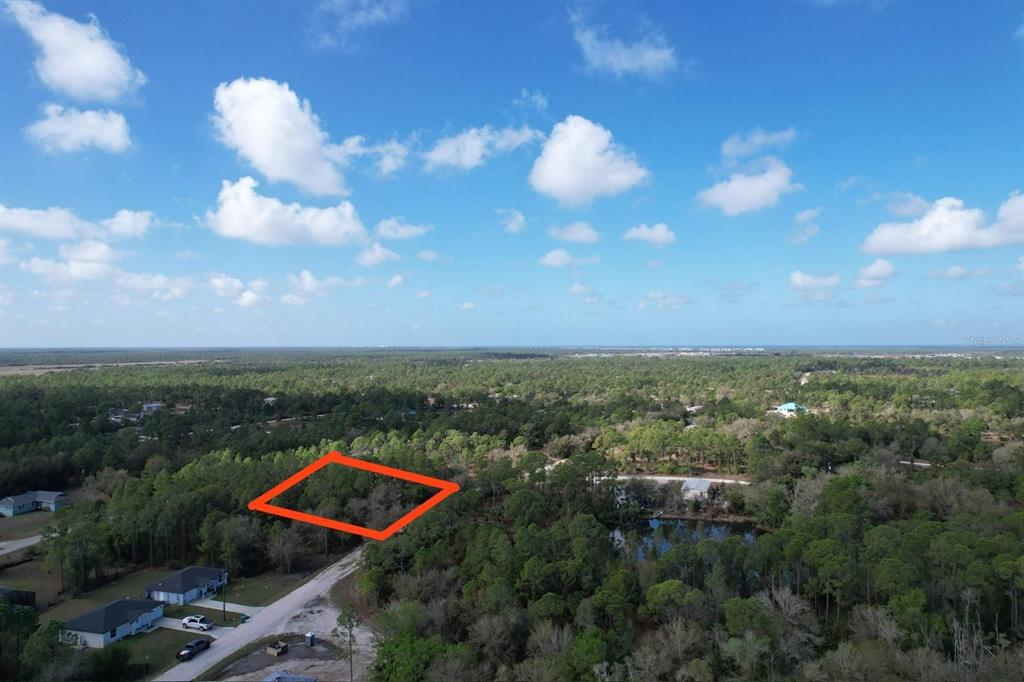 An aerial view shows a wooded residential lot outlined in orange near a paved road — 28101 LAURELWOOD DRIVE, PUNTA GORDA, FL