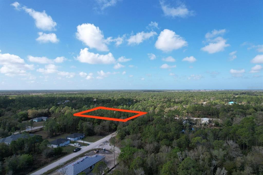 An aerial view shows a rectangular plot of land outlined in red amidst wooded surroundings — 28101 LAURELWOOD DRIVE, PUNTA GORDA, FL