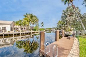 A wooden boat dock with a ladder overlooks a canal lined with palm trees — 1131 SE 5th Avenue, Pompano Beach FL 33060, POMPANO BEACH, FL